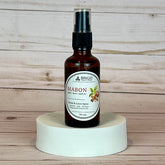 mabon room and linen spray Brown spray bottle labeled 'Mabon' on a white pedestal with wooden background