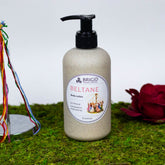 beltane body lotion rose jasmine clary sage and frankincense hand made natural shea butter for dry skin winter skin older skin autumn necessities celtic inspired made in kitsap county washington state image shows body lotion in a wheat straw eco friendly biodegradable and recyclable bottle on a moss background with a red flower
