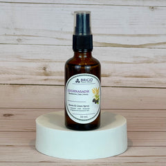 lughnasadh room and linen spray Brown spray bottle labeled 'Brigid' on a white pedestal against a wooden background