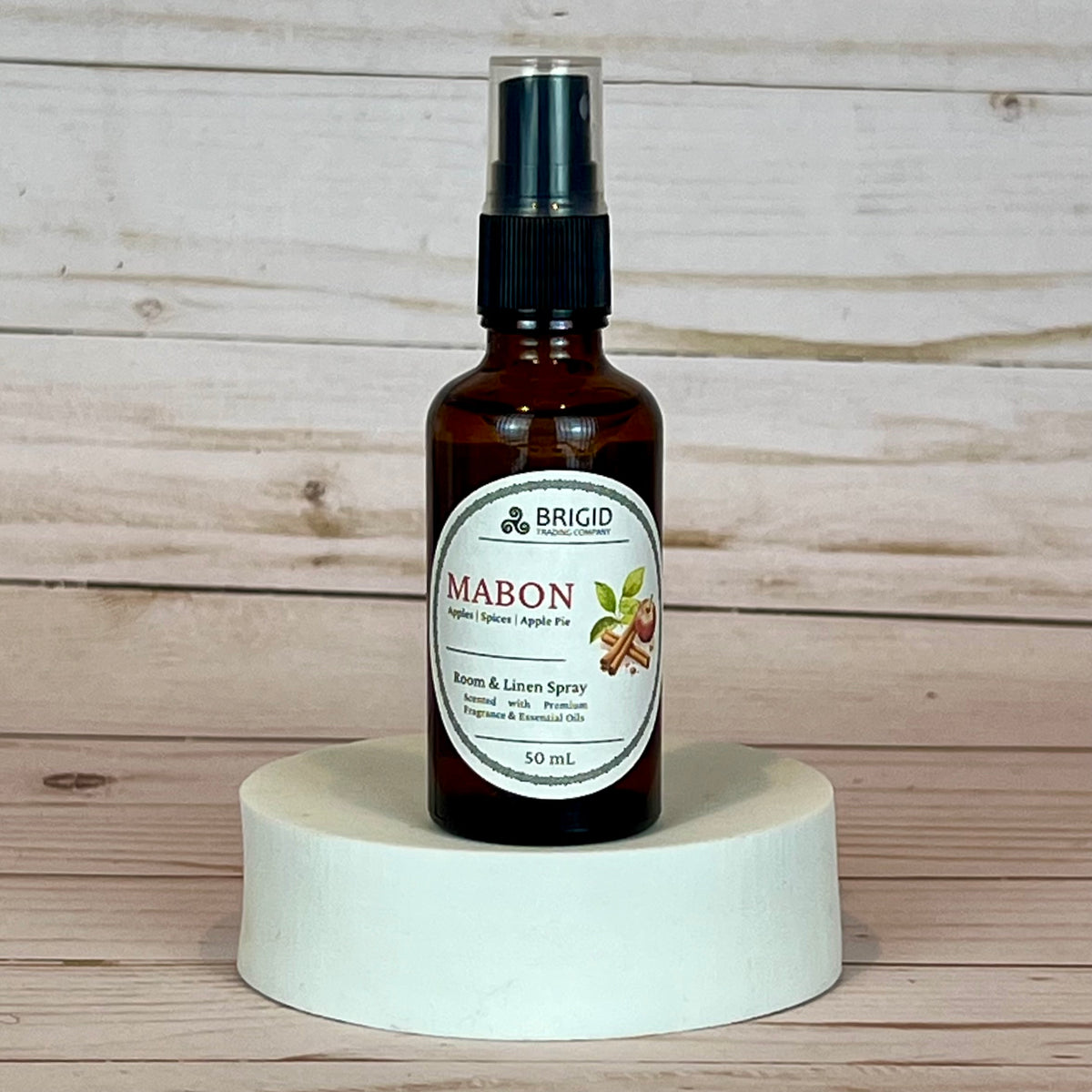 mabon room and linen spray Brown spray bottle labeled 'Mabon' on a white pedestal with wooden background