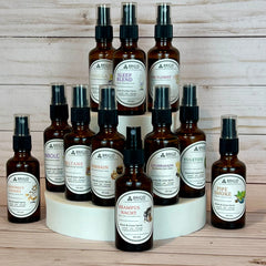 Brigid Trading Company room and linen spray collection in amber spray bottles on a wood surface