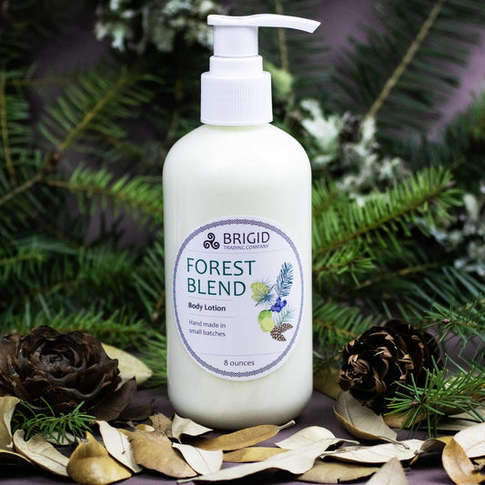 forest blend body lotion pump bottle in foreground studio photography dead leaves green pine and balsam in background and product in a plastic bottle with white label in foreground