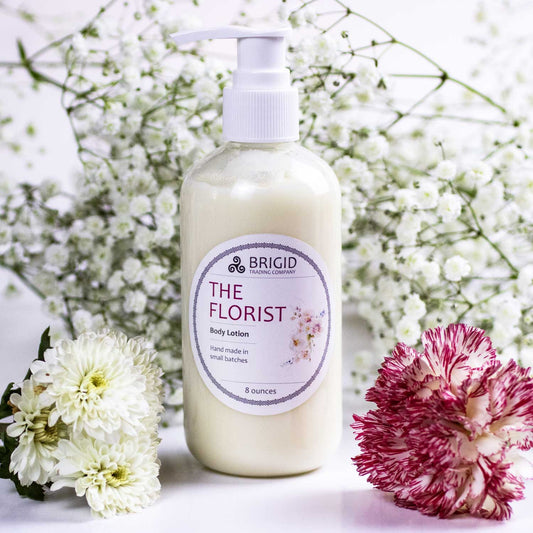 the florist body lotion floral studio shot white flowers pink flower babys breath in the background white light lotion bottle in the center featured by brigid trading company all natural shea butter olive oil kitsap county washington state united states