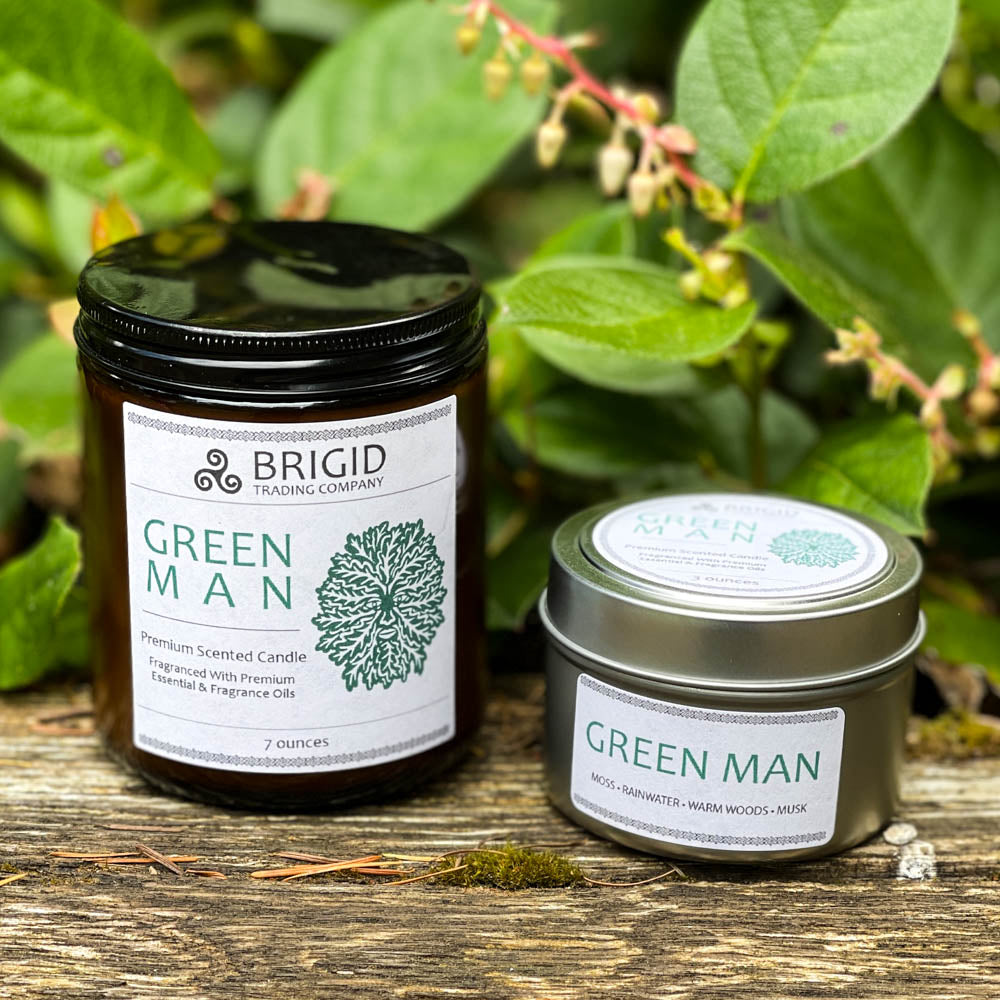 green man candles 7oz and 3oz outside shoot glass jar and tin two sizes original rainforest fresh scent with moss rainwater warm woods and musk celtic candles soy wax premium made in washington state hand made shown with salaal in background on tree stump