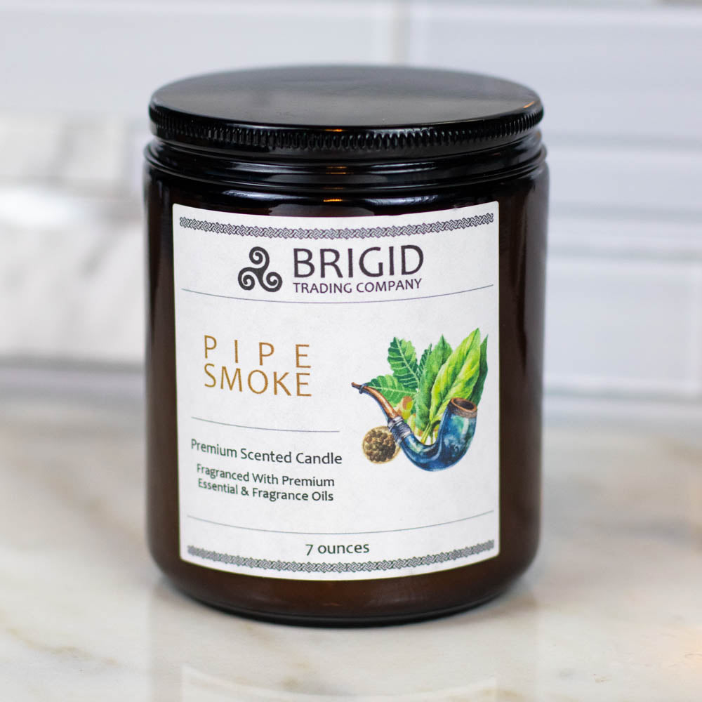 pipe smoke premium soy wax candle by brigid trading company gifts tobacco smoke oud wood and musk original photography by brigid trading company llc kitsap county washington state usa natural and handmade masculine woodsy woody scent celtic themed irish roots photo shows a dark marble background with light marble foreground and one amber glass jar candle