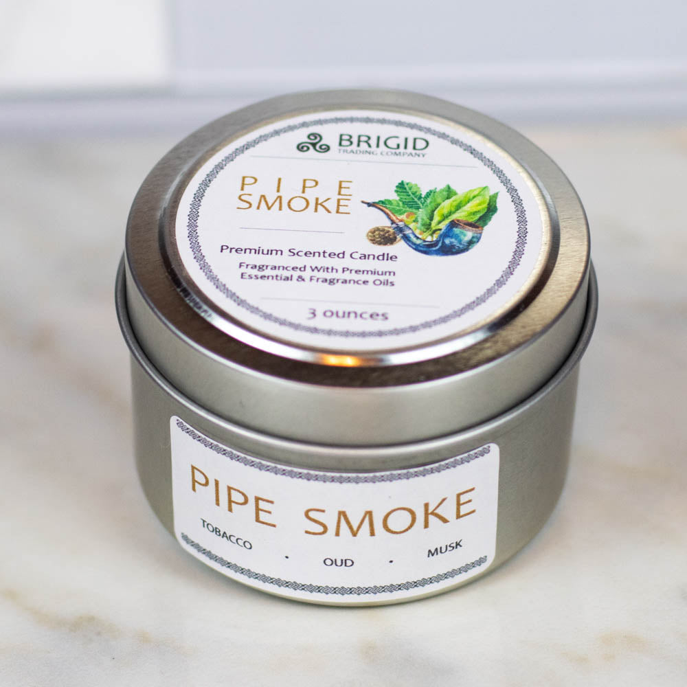 pipe smoke premium soy wax candle by brigid trading company gifts tobacco smoke oud wood and musk original photography by brigid trading company llc kitsap county washington state usa natural and handmade masculine woodsy woody scent celtic themed irish roots photo shows a dark marble background with light marble foreground and one tin small container candle 