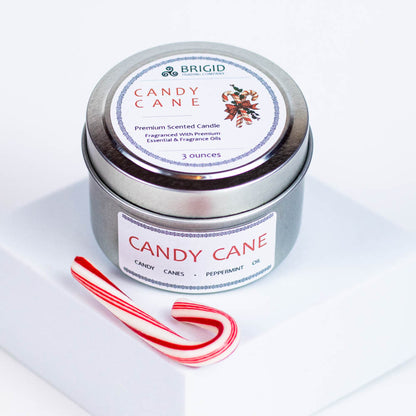 candy cane candle scent by brigid trading company christmas xmas yule yuletide irish christmas inspiration peppermint essential oil and peppermint candy cane fragrance oils the holidays holiday winter winter scent fresh santa claus gifts stocking stuffers small gifts for him for her gifts for mom dad sister brother cousin hard to find presents picky gift giving made in kitsap county washington state united states independent woman owned company 3 ounce candle in aluminum tin with small candy cane