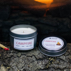 campfire mesquite smoke warm woods scented candle for camping fans mens gifts womens gifts for her for him outdoor fan presents hiking is in tents hand made in kitsap county independent american owned business usa grown sustainable soy wax not tested on animals original studio image by brigid trading company photography image shows one small candle three ounces in recyclable metal tin container candle with fire in background, matches and wooden log