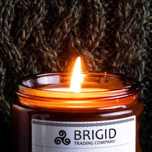 brigid candle burning with flame and irish sweater background