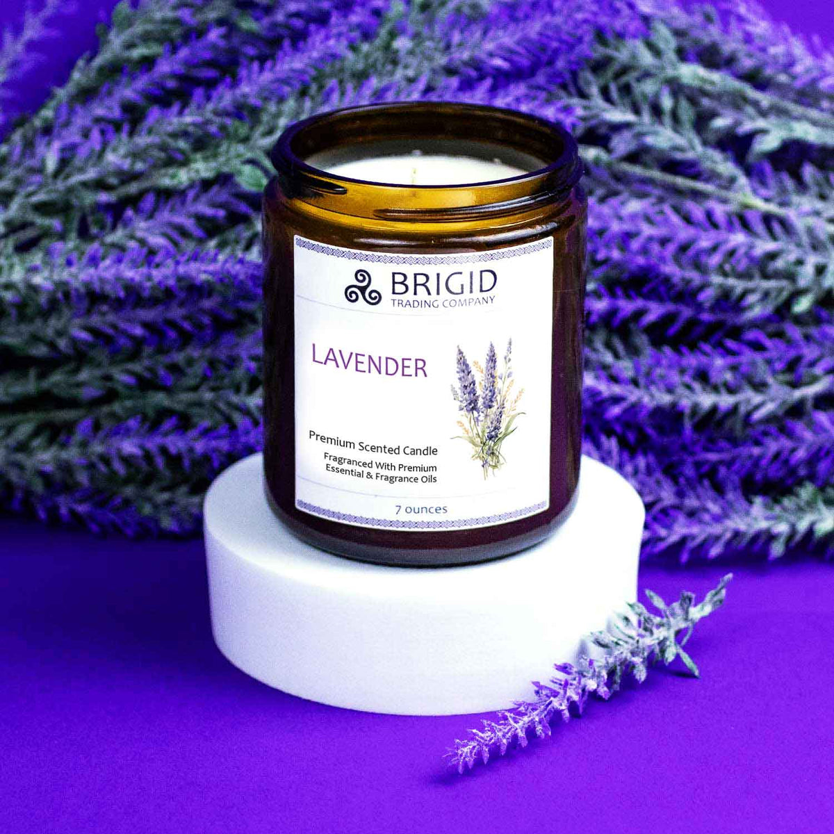 lavender candle bougie parfumee hand poured soy wax candle with natural ingredients studio shot of candle with lavender flowers and purple background on riser by brigid trading company kitsap county washington state united states