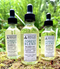 forest blend beard oil by brigid trading company natural beard oil with almond sunflower jojoba scented with essential oils natural juniper pine balsam cedar lime citrus fresh forest scented beard treatment conditioner hair care product photography by brigid trading company kitsap county washington state united states handmade in small batches glass jars with black dropper tops triskellion logo