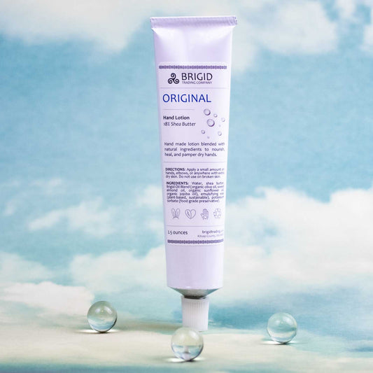 original hand lotion tube by brigid trading company fragrance free one and a half ounces image of hand lotion tube on blue sky with clouds background and clear sphere details