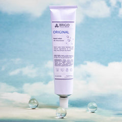 original hand lotion tube by brigid trading company fragrance free one and a half ounces image of hand lotion tube on blue sky with clouds background and clear sphere details