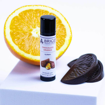 chocolate orange natural lip balm hand made brigid trading company llc lip balm kitsap county washington state studio image with orange sliced and chocolate orange pieces with lip balm tube product