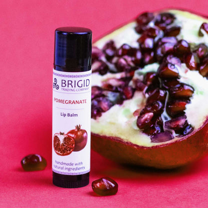 pomegranate lip balm brigid trading company kitsap county washington state red background lip balm with pomegranate fruit seeds