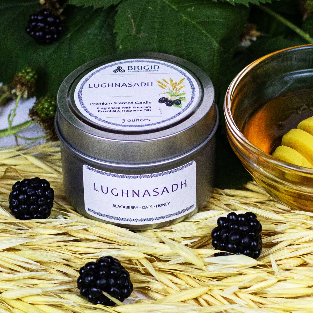 lughnasadh candle 3oz by brigid trading company llc blackberry oat honey scent premium soy wax candle photography original by brigid trading company blackberry leaves and plants in background with fresh blackberries sitting on dried oats with bowl of honey and honey spoon next to candle in amber glass jar with lughnasadh on the label 2024 kitsap county washington state united states