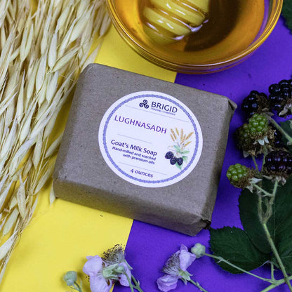 goats milk soap natural by brigid trading company lughnasadh scent hand milled blackberry oat meal honey image shows dried wheat and fresh blackberries with honey bowl detail background is yellow and purple kitsap county washington state