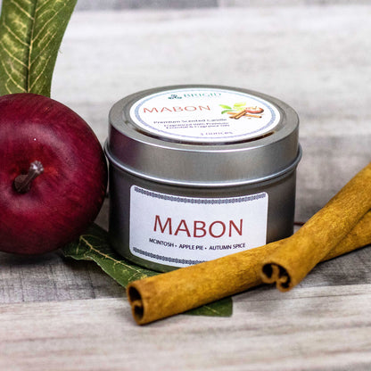 mabon fall scent apple cinnamon and spices thanksgiving fall natural soy wax candles hand made washington state by hand real people independent business essential oil natural organic image shows wood background with red apple and one three 3 ounce candle